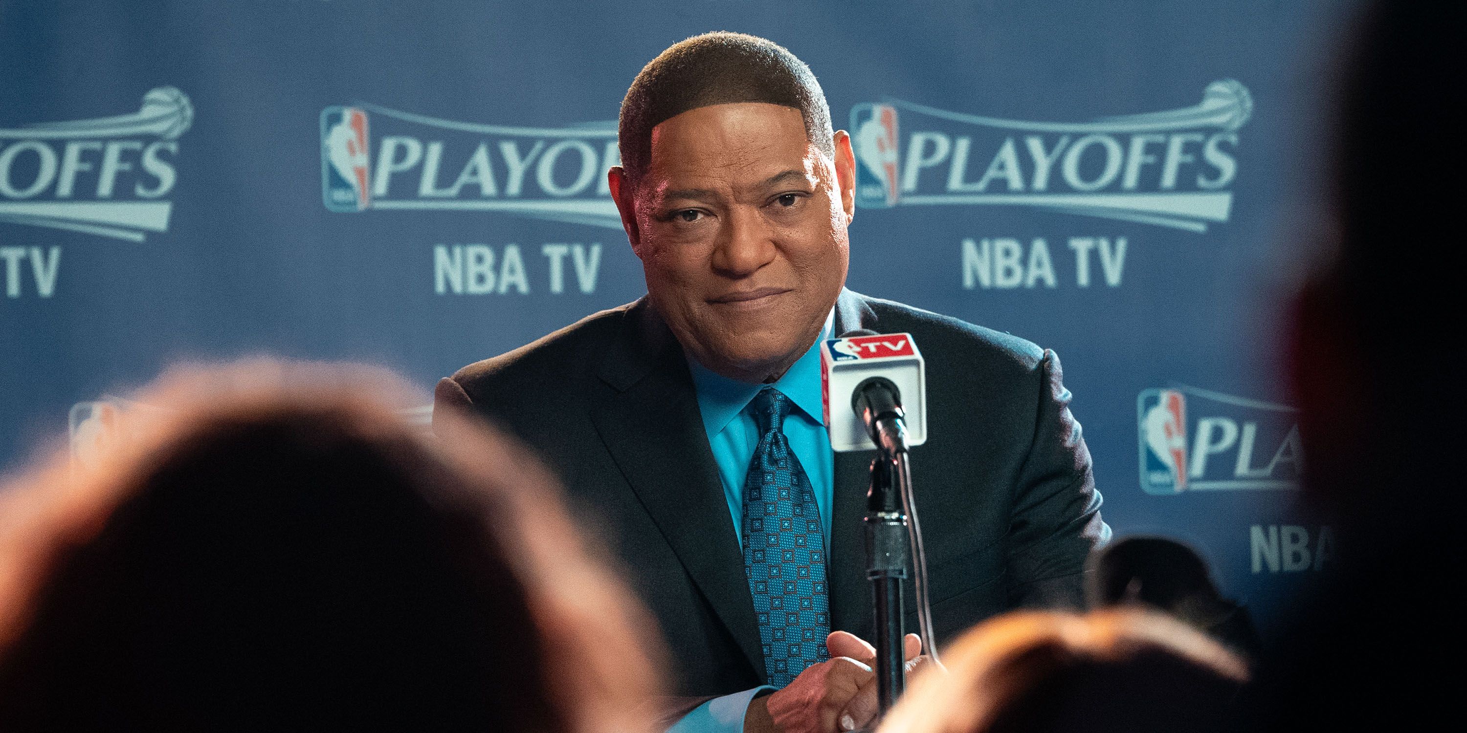 Laurence Fishburne as Doc Rivers at a press conference in Clipped.