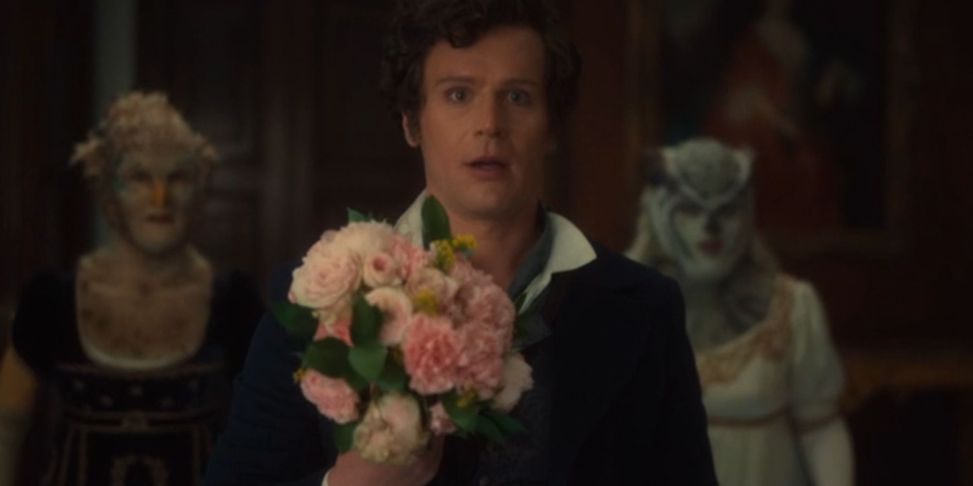 Jonathan Groff as Rogue looking shocked in Doctor Who as he holds flowers
