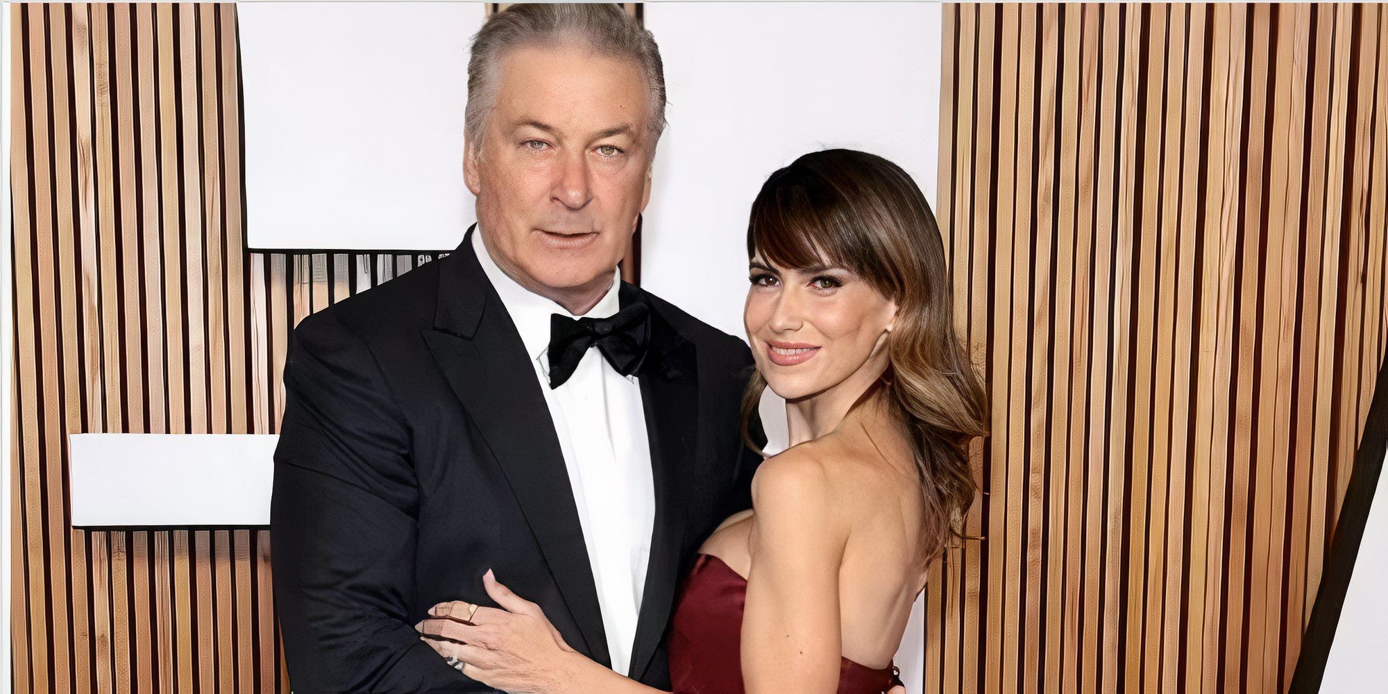 Os Baldwins Alec Baldwin e Hilaria Baldwin posam em um tapete vermelho com fundo de painel de madeira