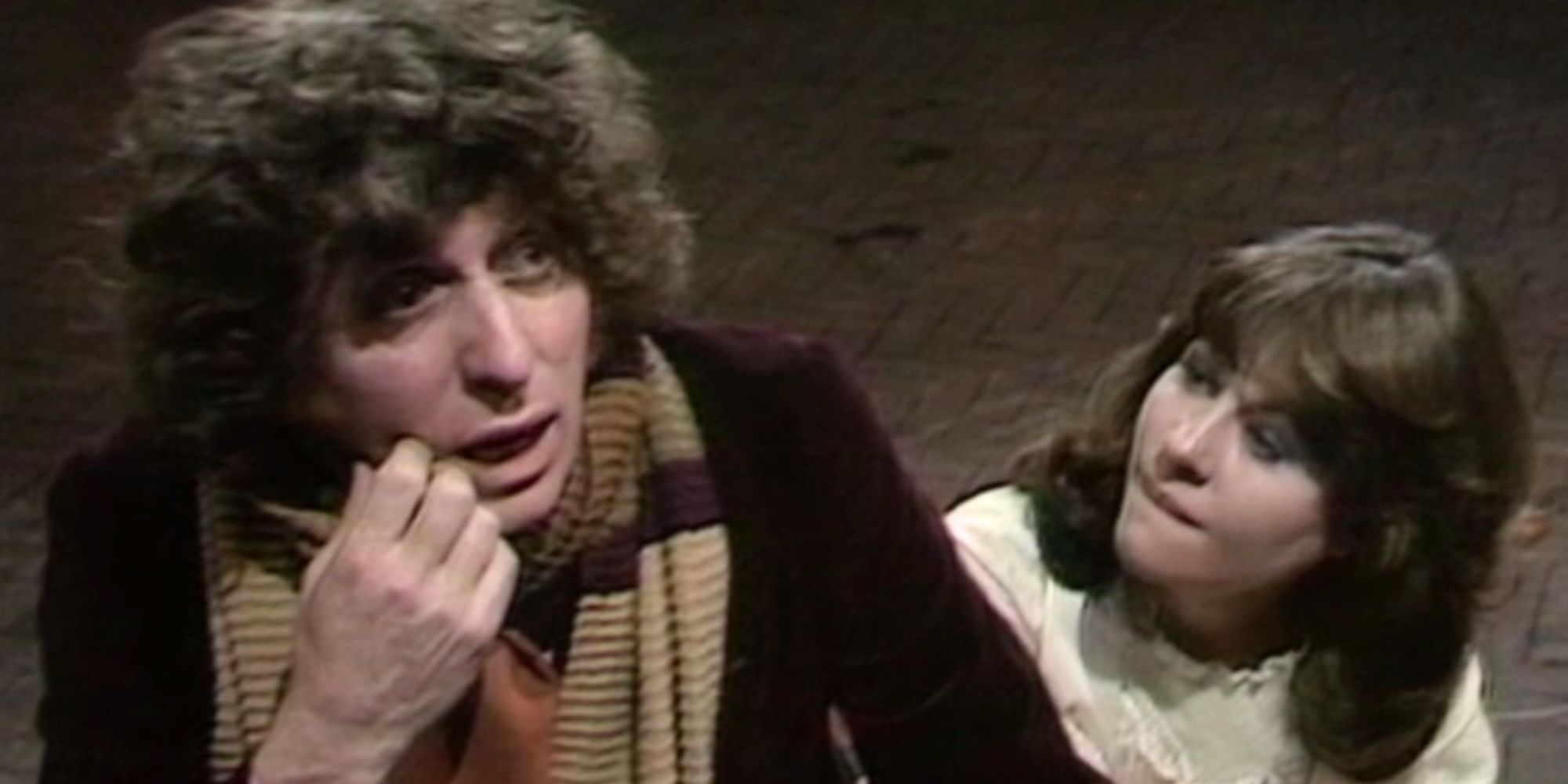 Tom Baker parece preocupado como o Quarto Doutor em Doctor Who enquanto Sarah Jane Smith de Elisabeth Sladen o observa parecendo preocupado