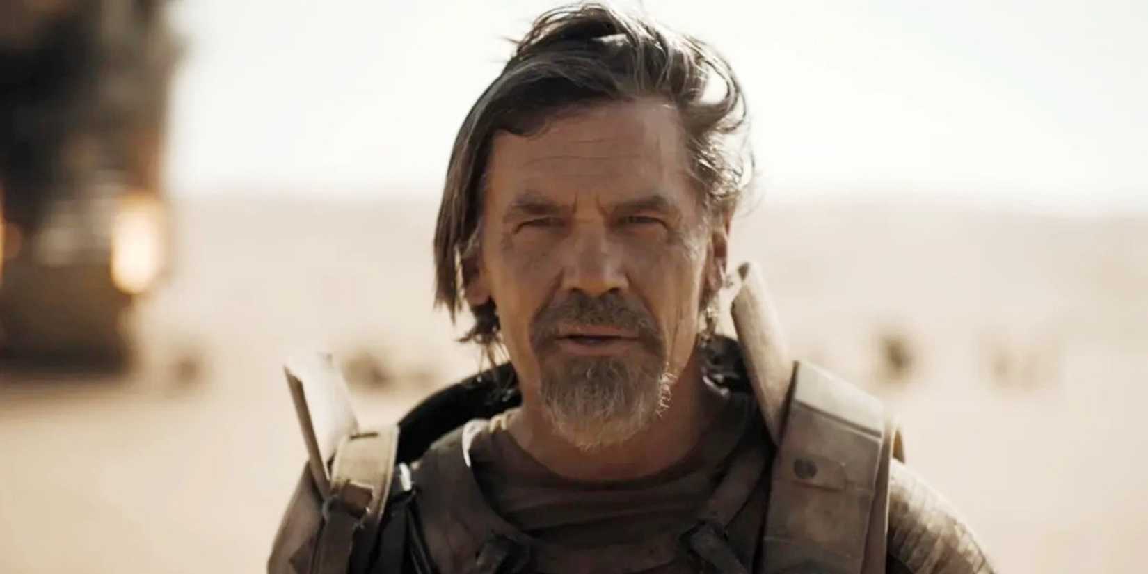 Gurney (Josh Brolin) smiling while standing in the desert in Dune: Part Two