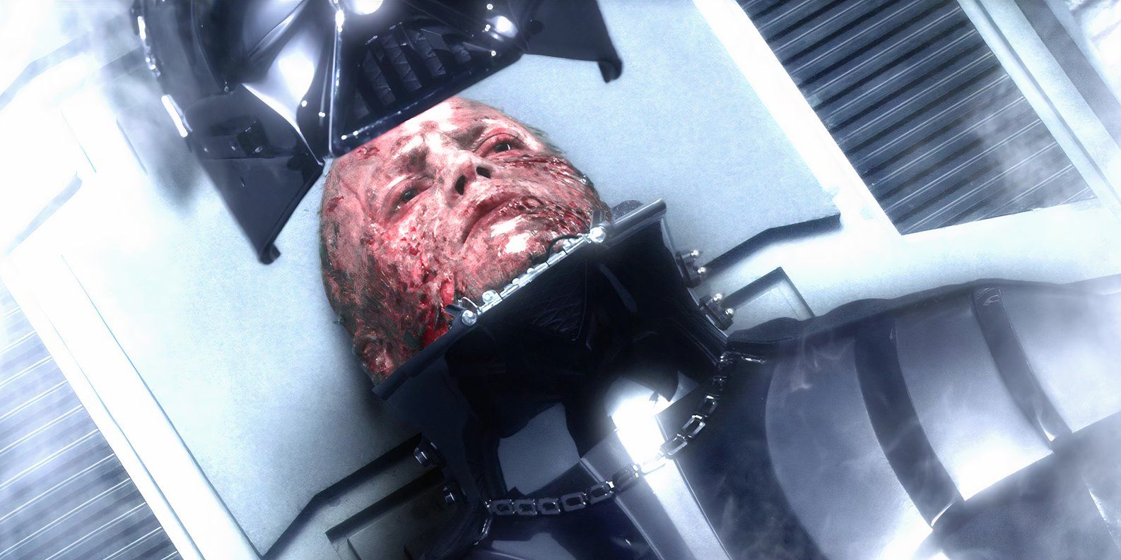 Darth Vader (Hayden Christensen) sits on a table while his helmet is lowered onto his head in Star Wars: Episode III - Revenge of the Sith