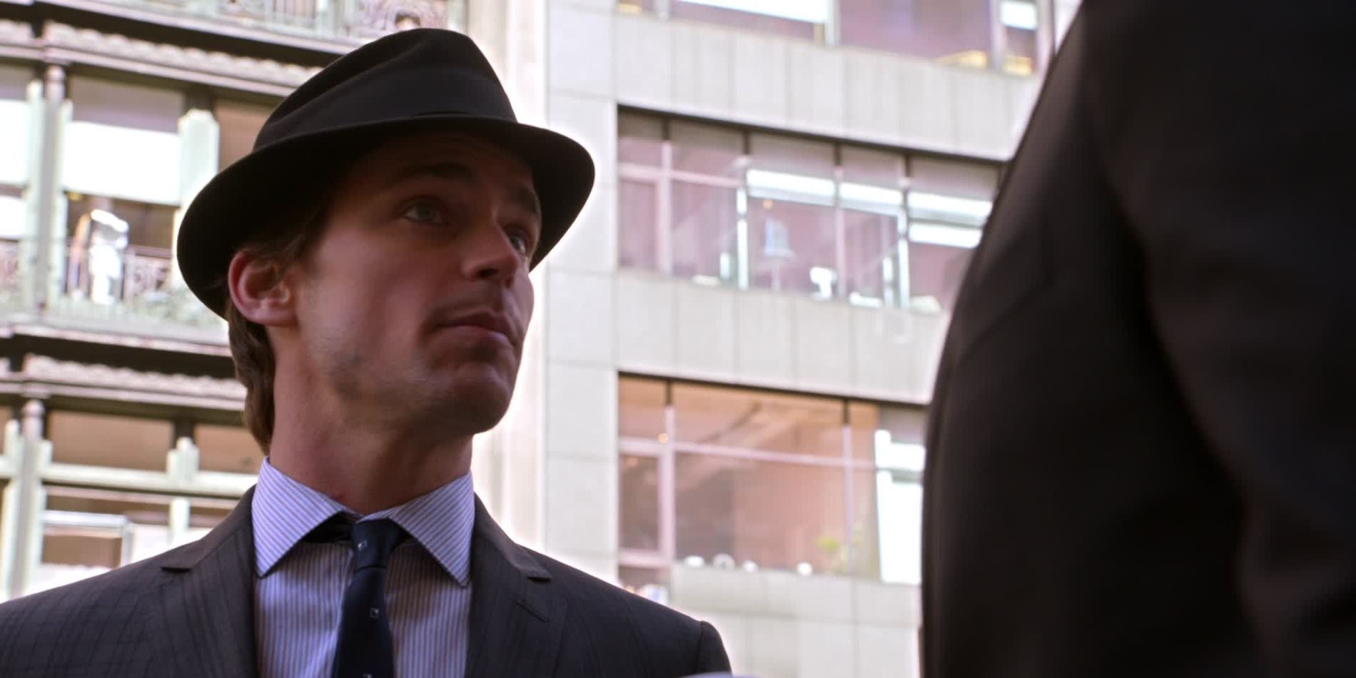 Neal wearing a hat on the street in White Collar.