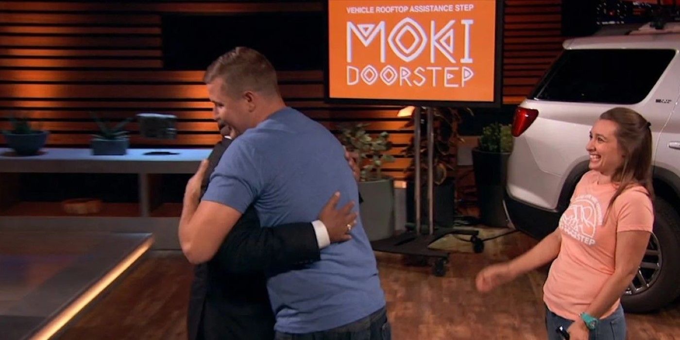 Zachary Brown abraçando Daymond enquanto Alyssa comemora na apresentação do Moki Doorstep no Shark Tank.-1