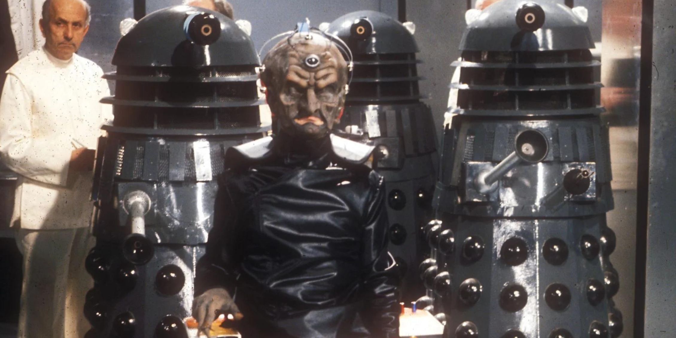 Doctor Who Davros in his Dalek-like wheelchair, flanked by several Kaled soldiers