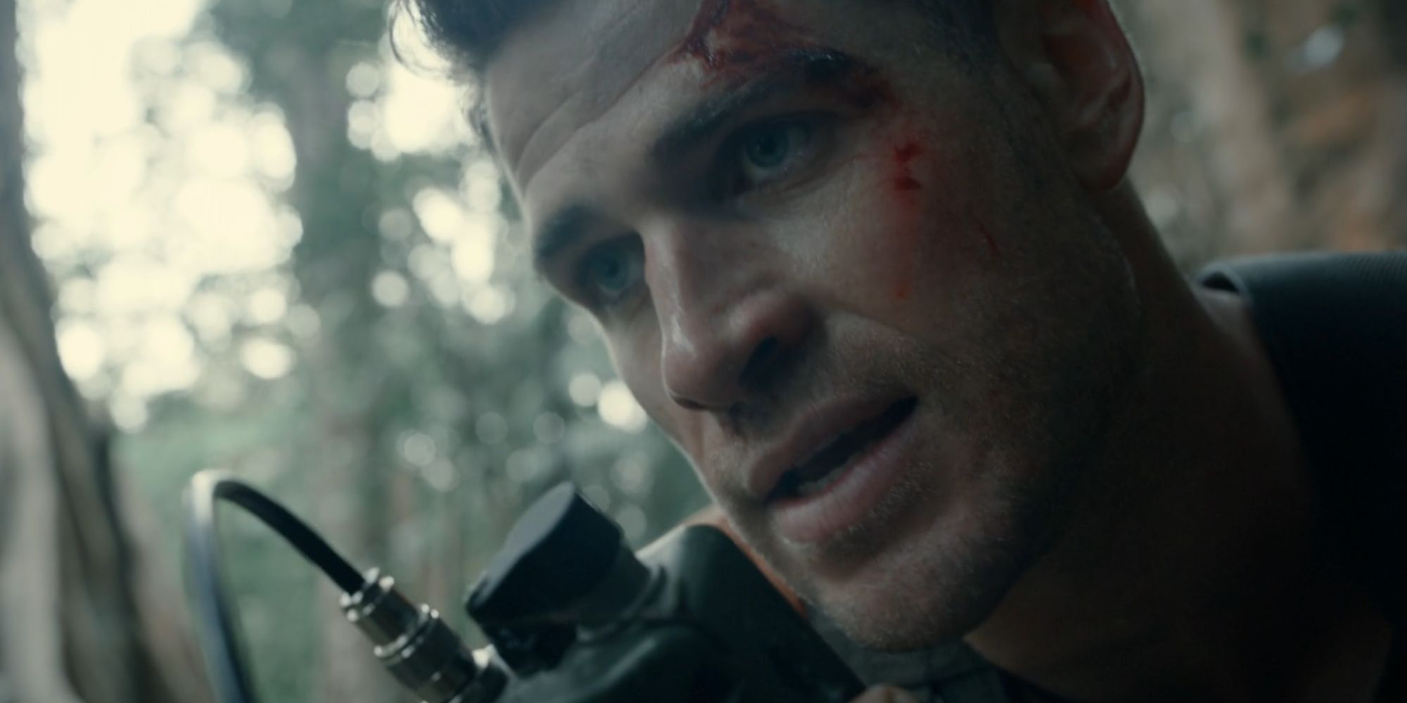 Liam Hemsworth as Sgt. Kinney speaking on a walkie-talkie in Land of Bad