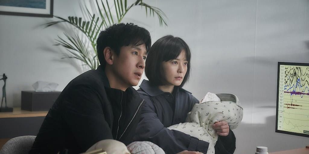 Lee Sun-kyun und Jung Yu-mi sitzen mit einem Baby in Jason Yus Mystery-Horrorfilm Sleep (2023)