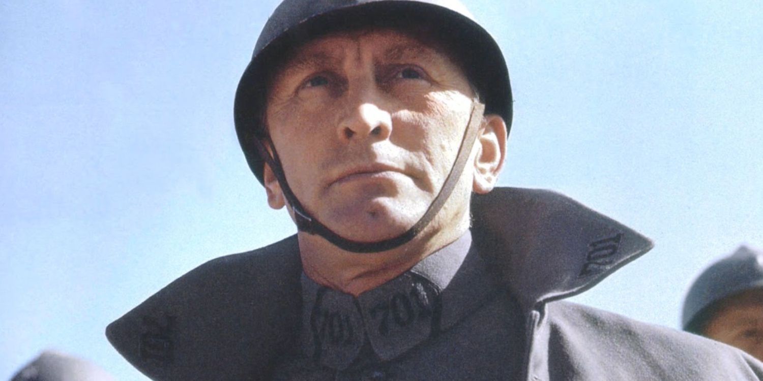 Uma foto de Kirk Douglas em Paths Of Glory em 1957. Ele está usando um capacete e uniforme militar com gola levantada. 