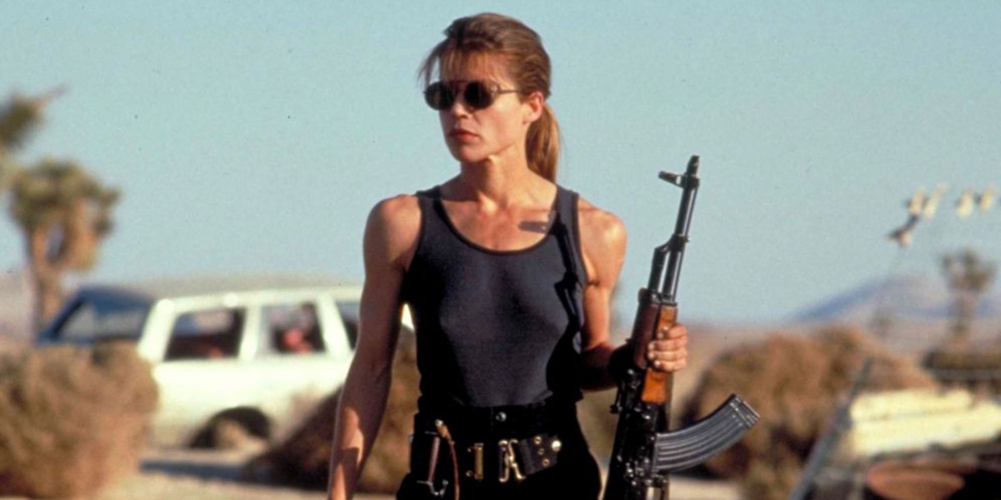 Linda Hamilton lyk heldhaftig met 'n geweer as Sarah Connor in Terminator