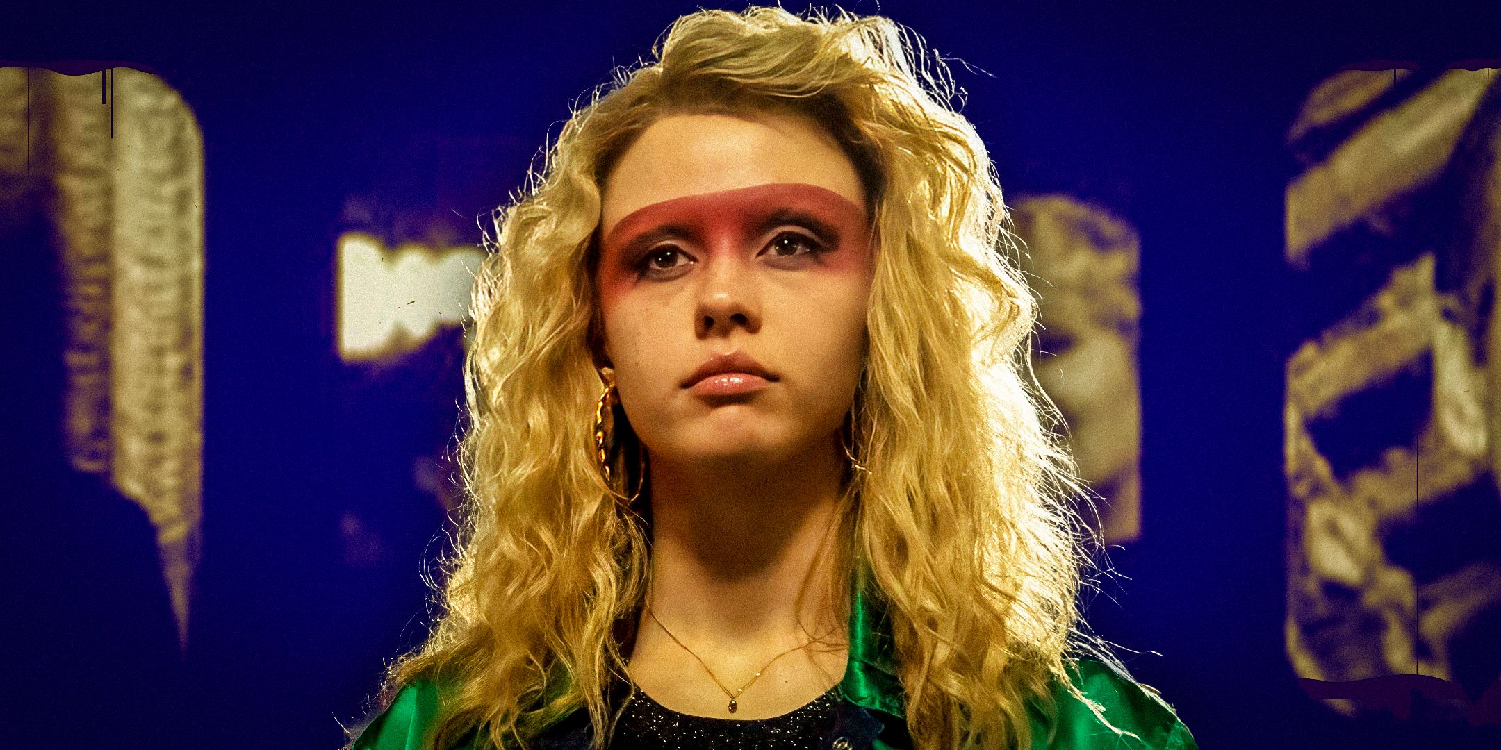 A still of Mia Goth as Maxine in MaXXXine. She wears a green varsity jacket and red spray-painted eyeshadow.