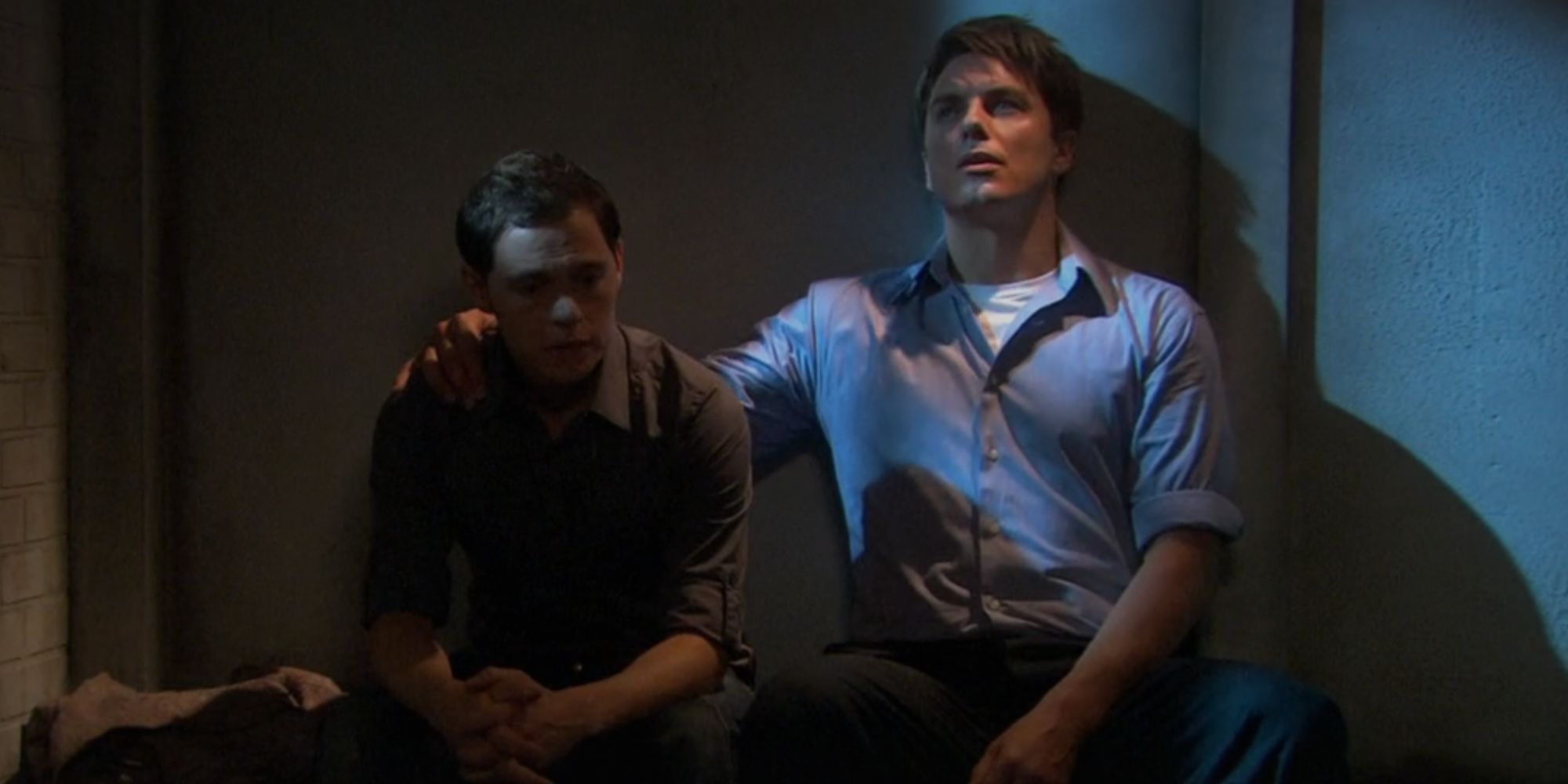 John Barrowman as Captain Jack Harkness in Torchwood with his arm around Burn Gorman's Owen Harper