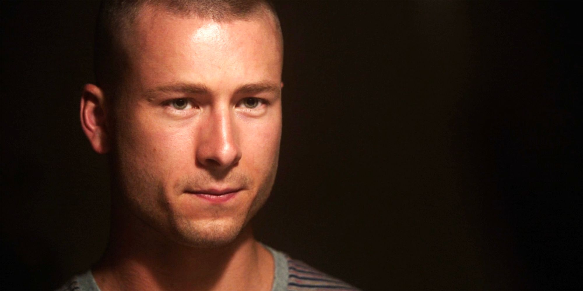 A close up of Glen Powell looking serious and detemined in NCIS