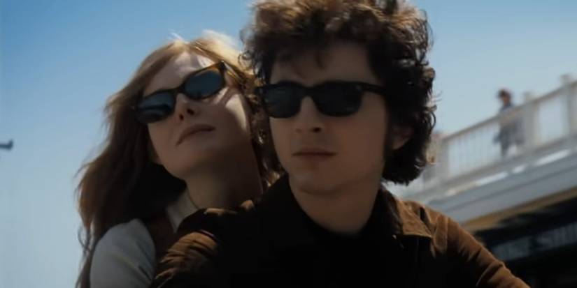 Timothée Chalamet as Bob Dylan and Elle Fanning as Sylvie Russo riding a motorcycle in A Complete Unknown
