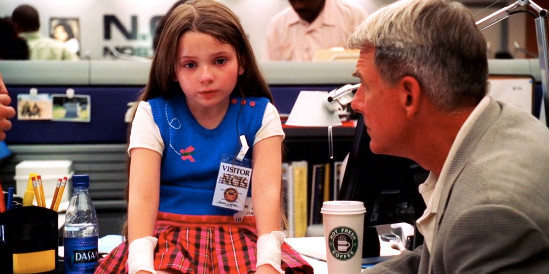 Abigail Breslin sitting on a desk talking to Gibbs in NCIS