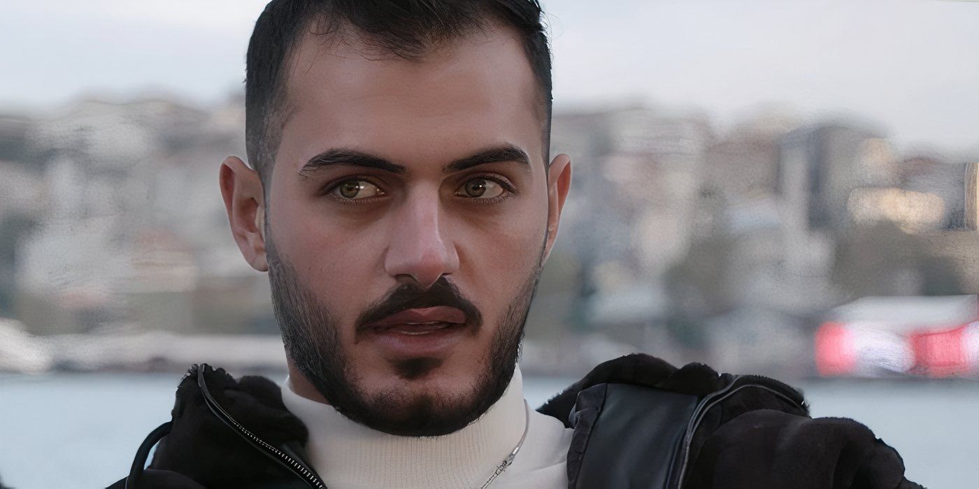 Adnan Abdelfattah In 90 Day Fiance by the seaside in black jacket and white turtleneck looking angry