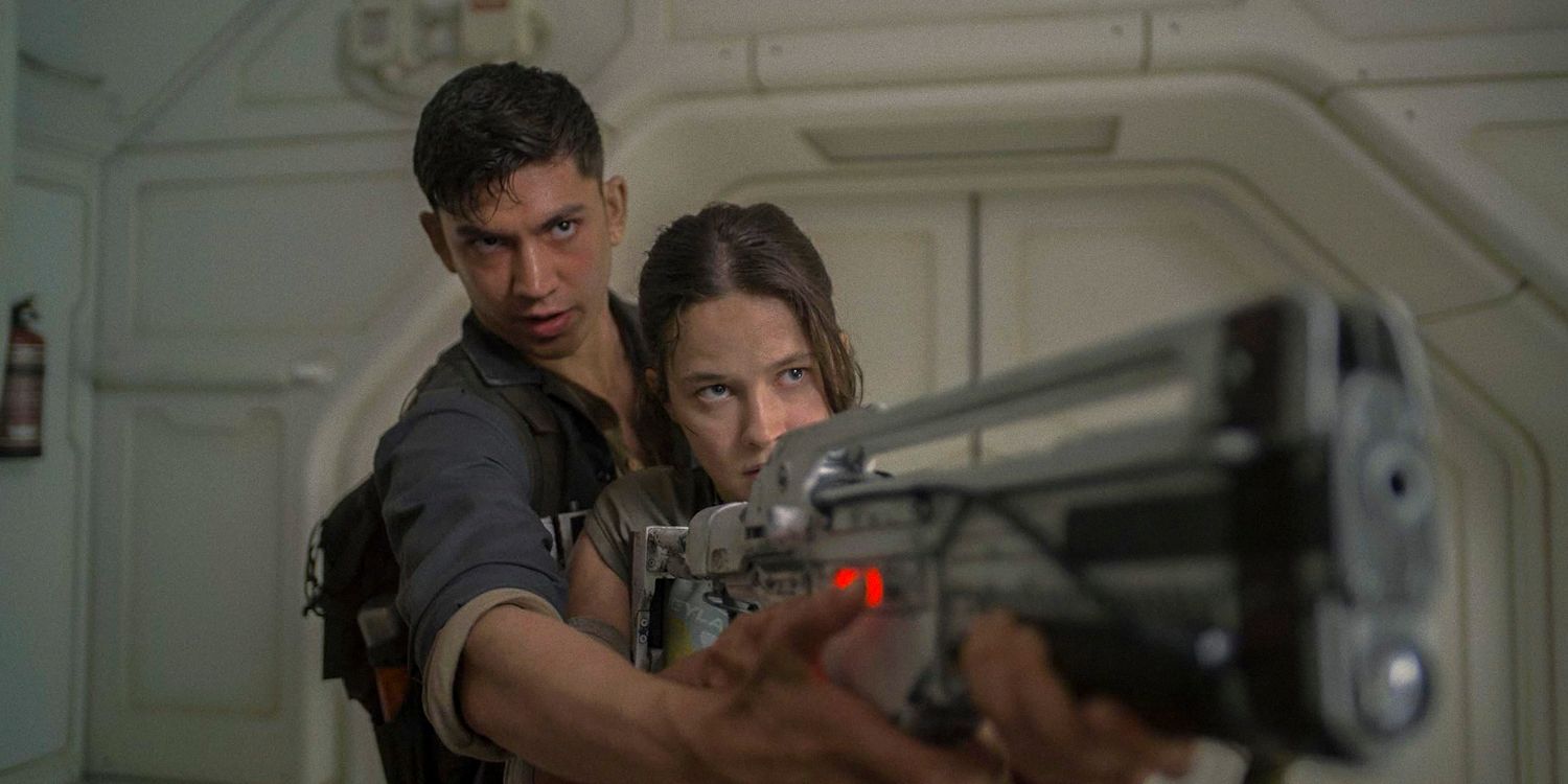 Tyler (Archie Renaux) helping Rain Carradine (Cailee Spaeny) aim a gun in Alien: Romulus