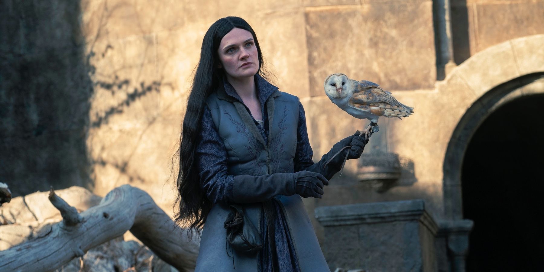 Alys Rivers (Gayle Rankin) holding a barn owl standing outside of Harrenhal in House of the Dragon season 2