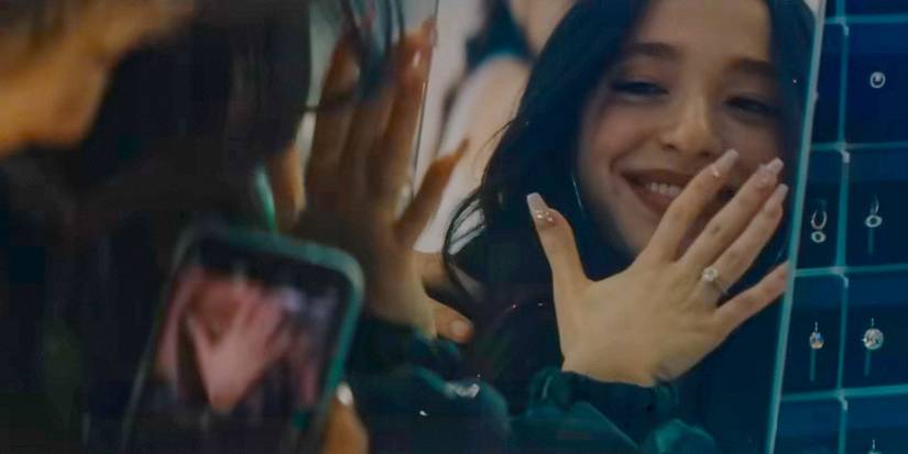 Ani (Mikey Madison) looking at her reflection in the mirror with her engagement ring in Anora