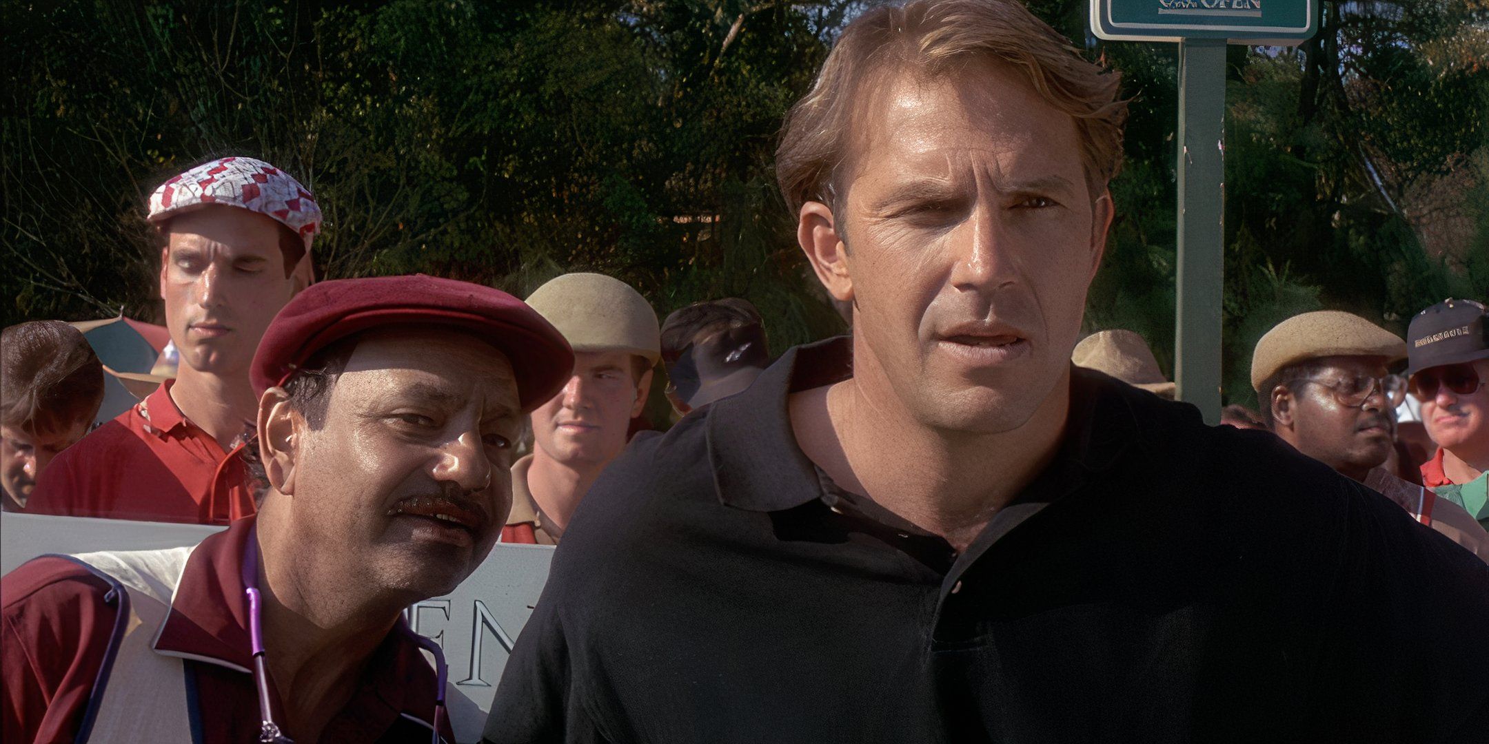 Cheech Marin e Kevin Costner olham para o campo de golfe. 