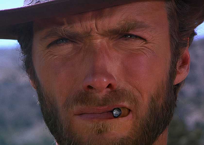 Clint Eastwood squinting under a cowboy hat with a cigar in the corner of his mouth in The Good the Bad and the Ugly