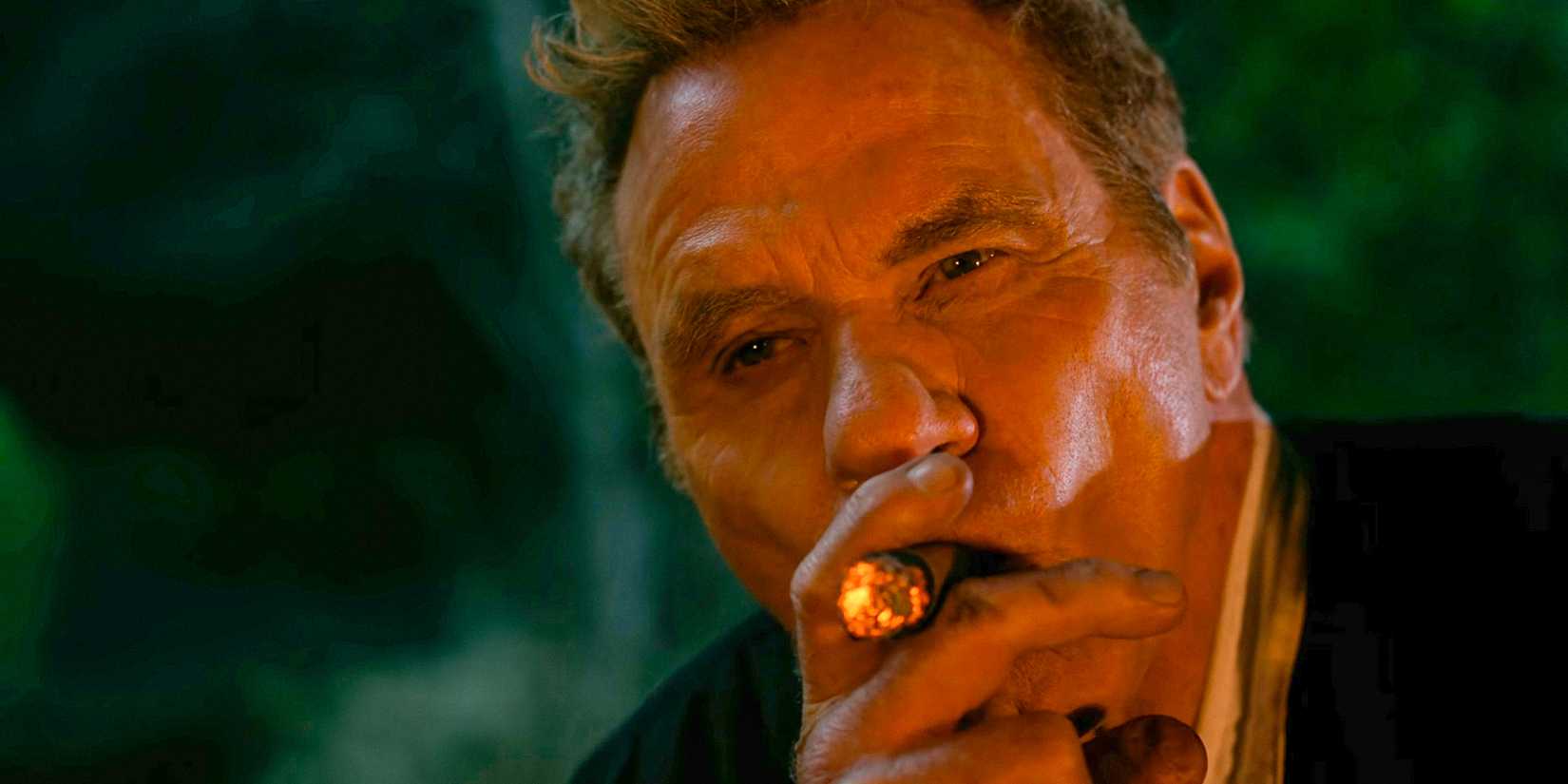 John Kreese (Martin Kove) looking thoughtful while smoking a cigar in Cobra Kai season 6
