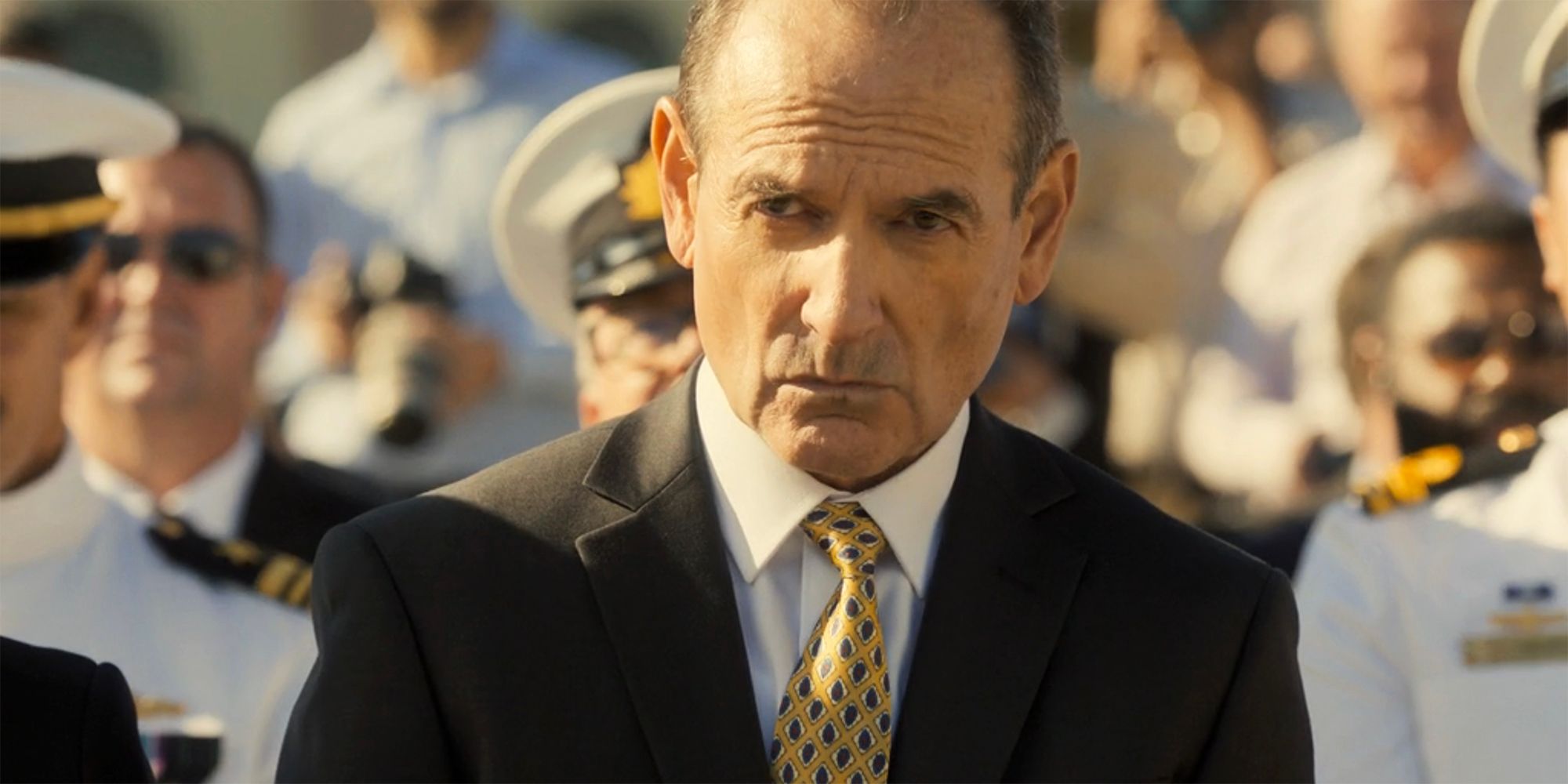 Colonel Rankin walking through a crowd and wearing a suit in NCIS Sydney