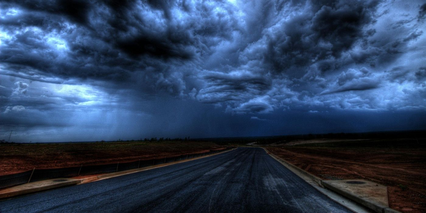 Uma estrada escura sob um céu noturno nublado