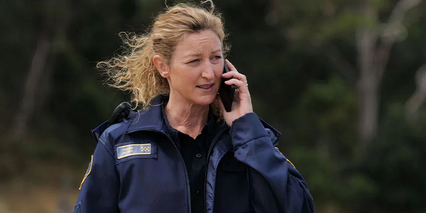 Dulcie habla por teléfono mientras está de pie en una playa ventosa en Dedloch