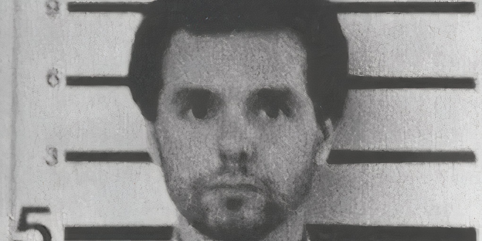 Donald Harvey against a height chart in his grainy black and white mugshot