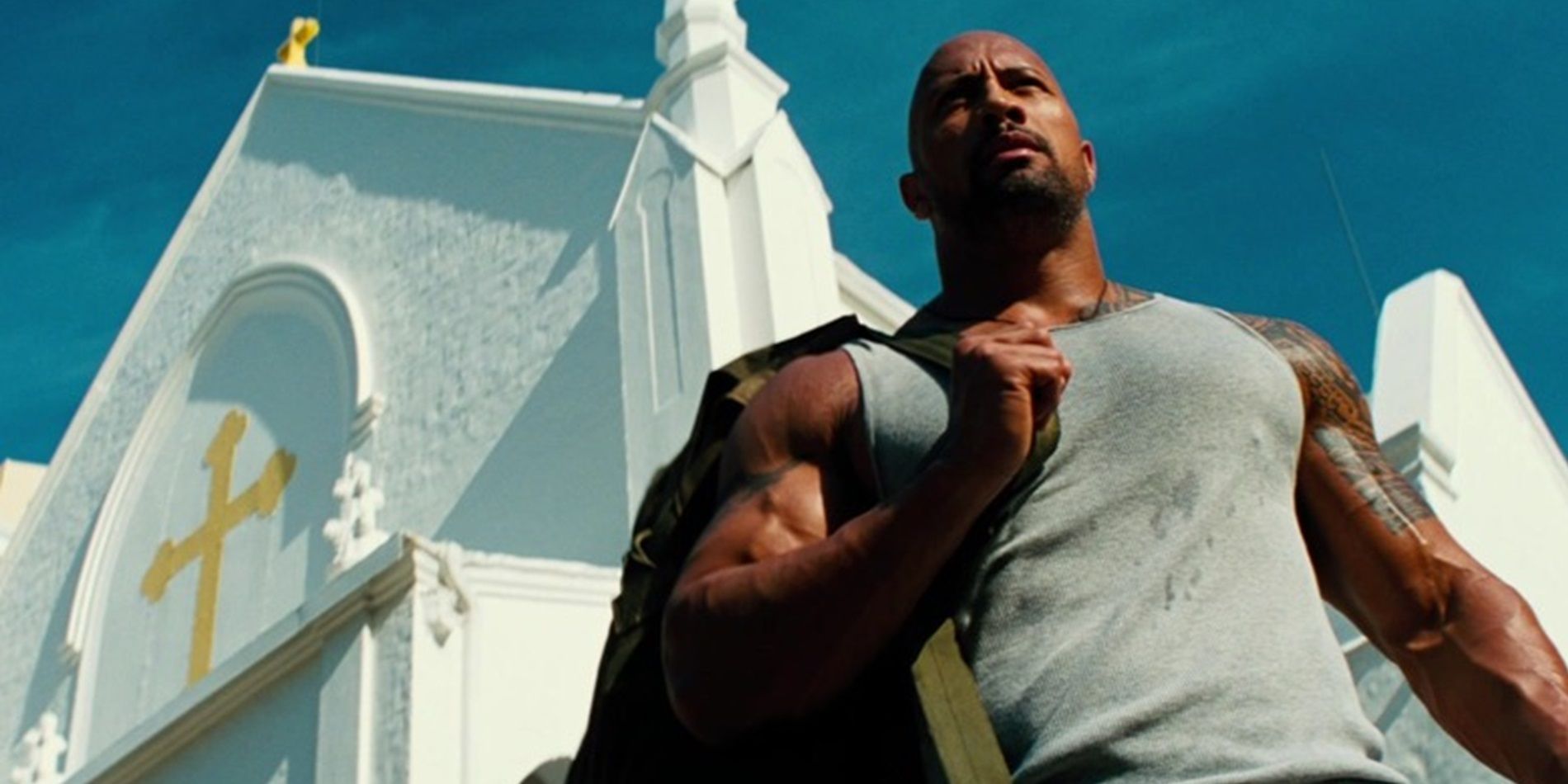 Paul Doyle (Dwayne Johnson) em pé do lado de fora de uma igreja em Pain and Gain