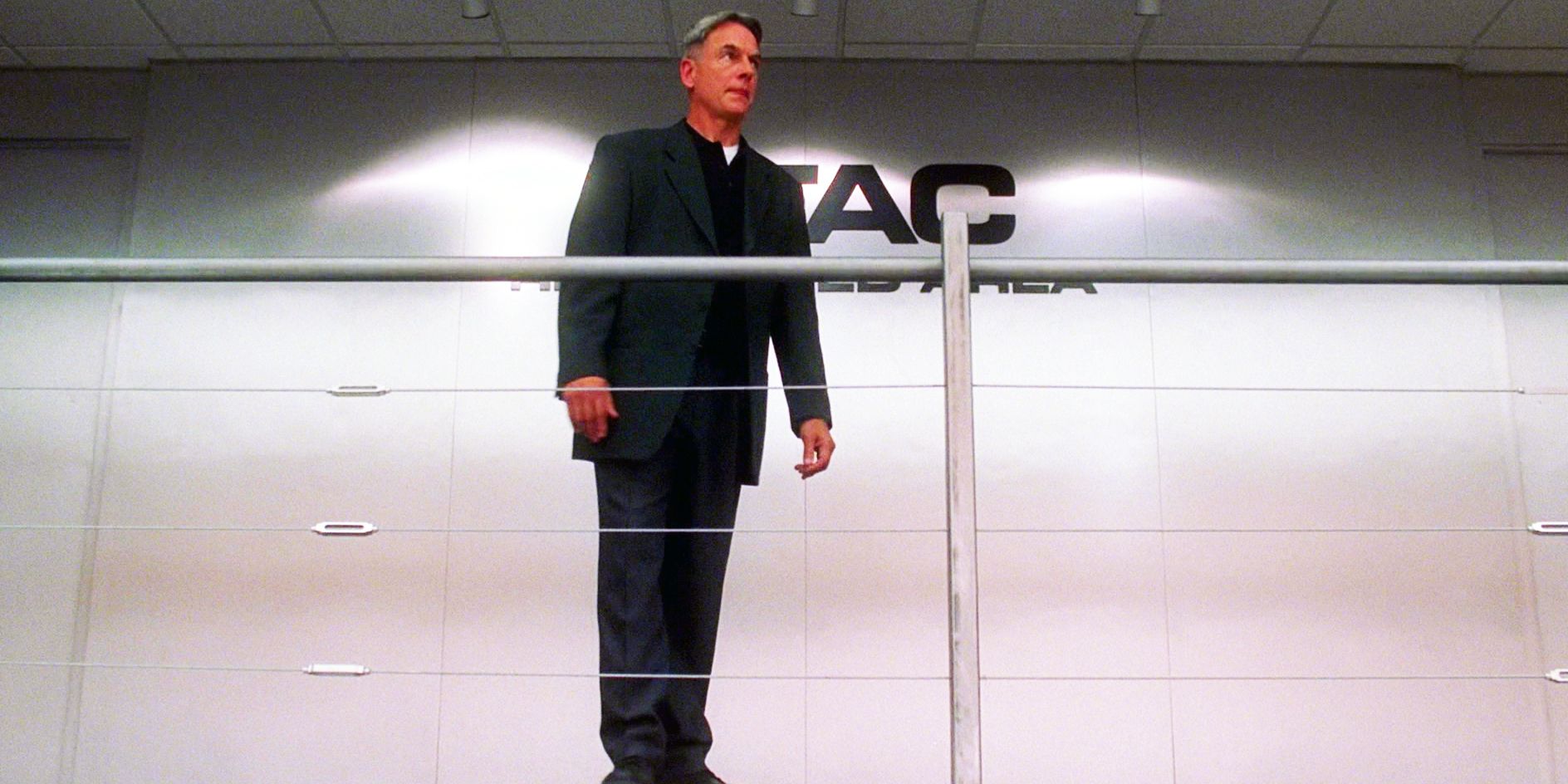 Gibbs standing alone in front of the MTAC sign in NCIS