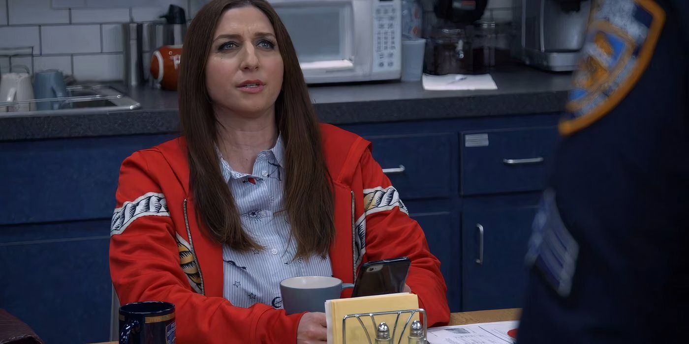 Gina sentada con un vestido rojo en Brooklyn Nine-Nine