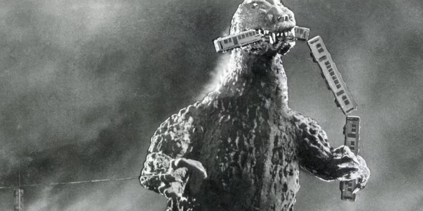 Godzilla, 1954 - Godzilla is eating a piece of a vehicle in its mouth 