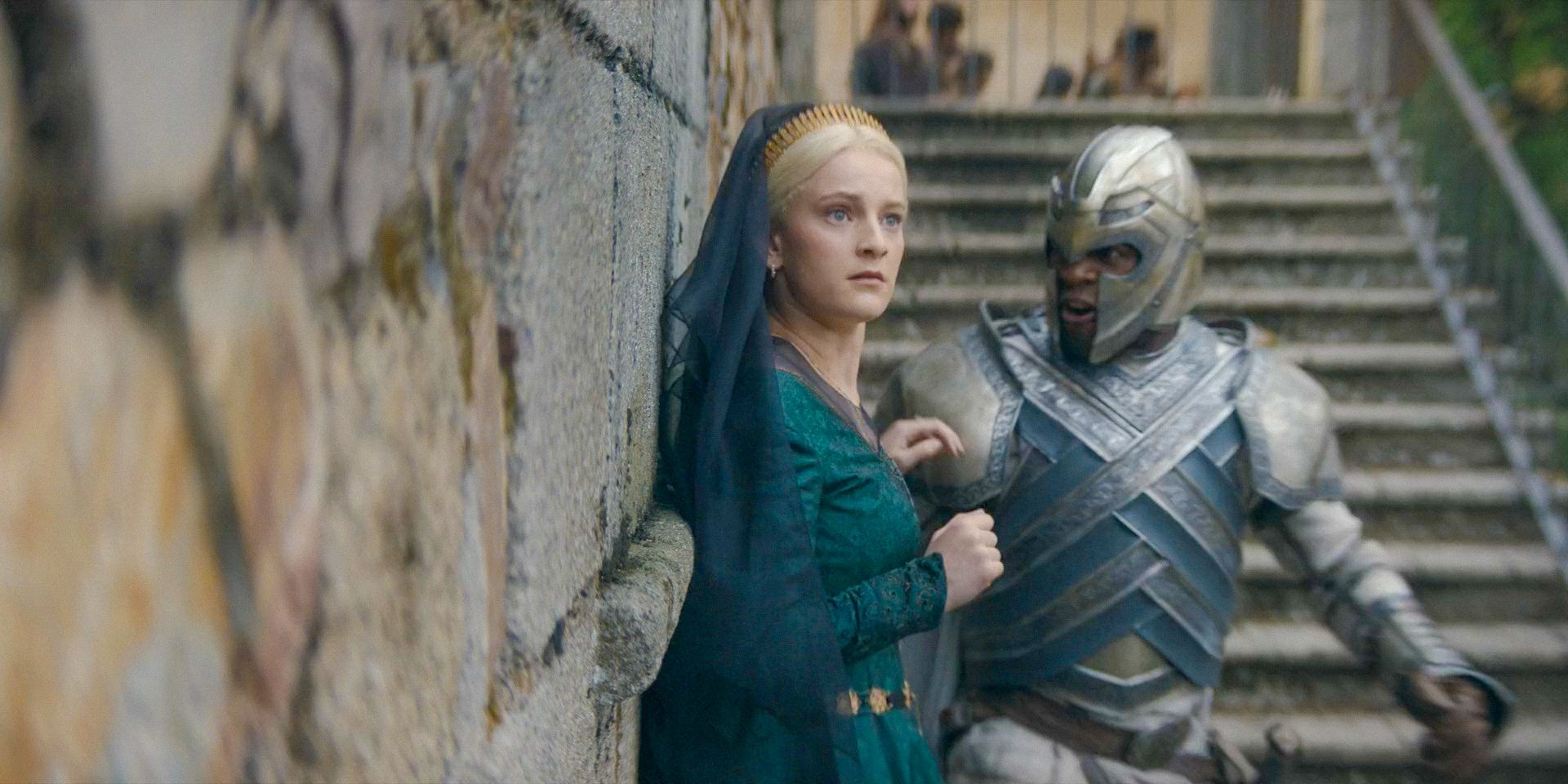 Helaena (Phia Saban) assustada com a multidão enquanto um guarda a acompanha até a carruagem em House of the Dragon, temporada 2, episódio 6