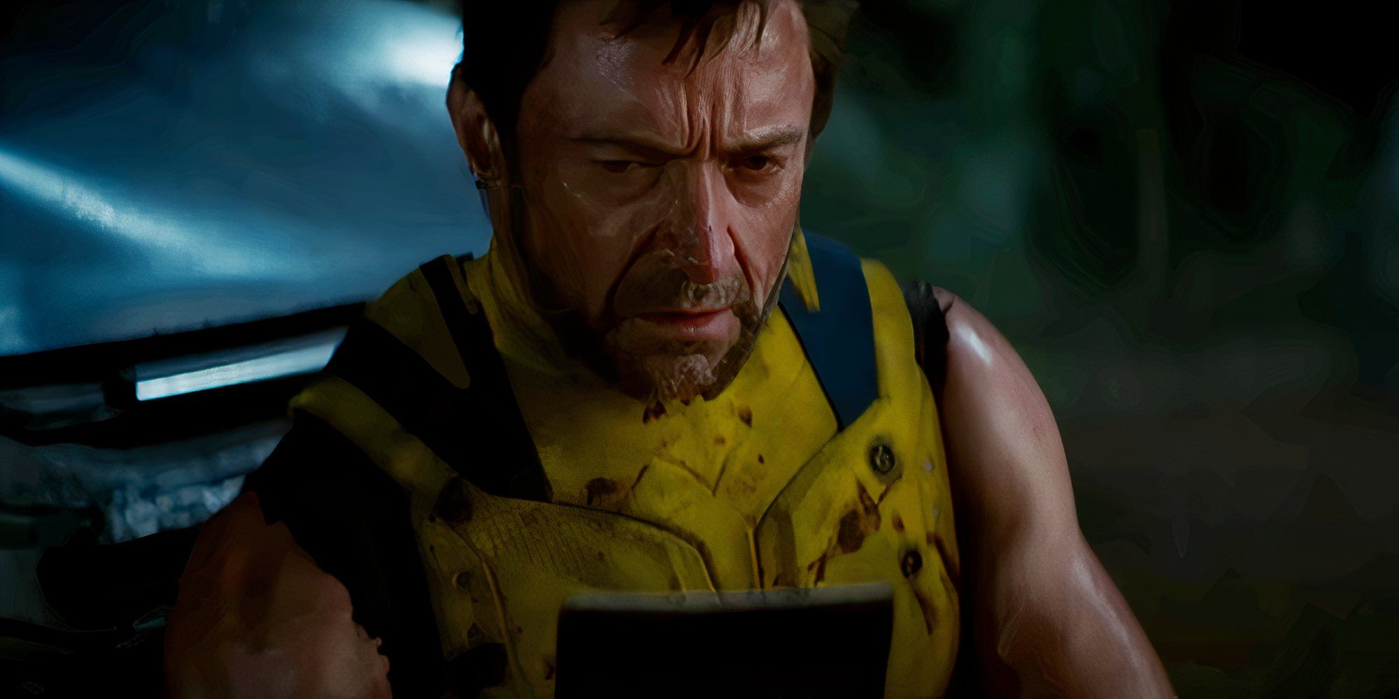 Hugh Jackman olha para uma foto como Wolverine em Deadpool e Wolverine