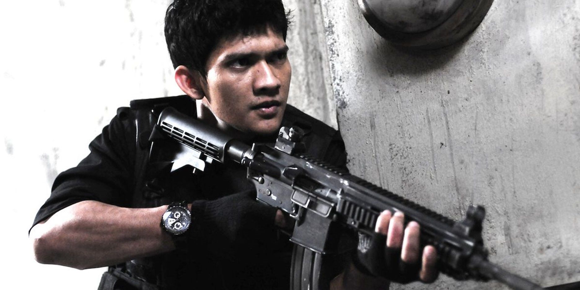 Iko Uwais with an assault rifle in The Raid