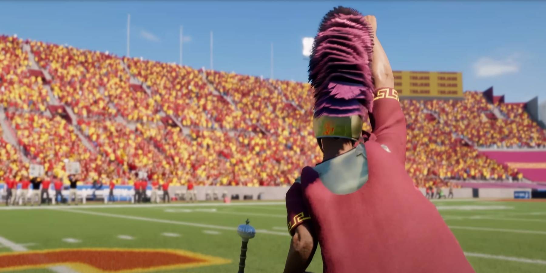 Membro da banda College Football 25 USC em traje de guerreiro romano enfiando a espada no meio do campo como um ritual pré-jogo para toda a torcida local