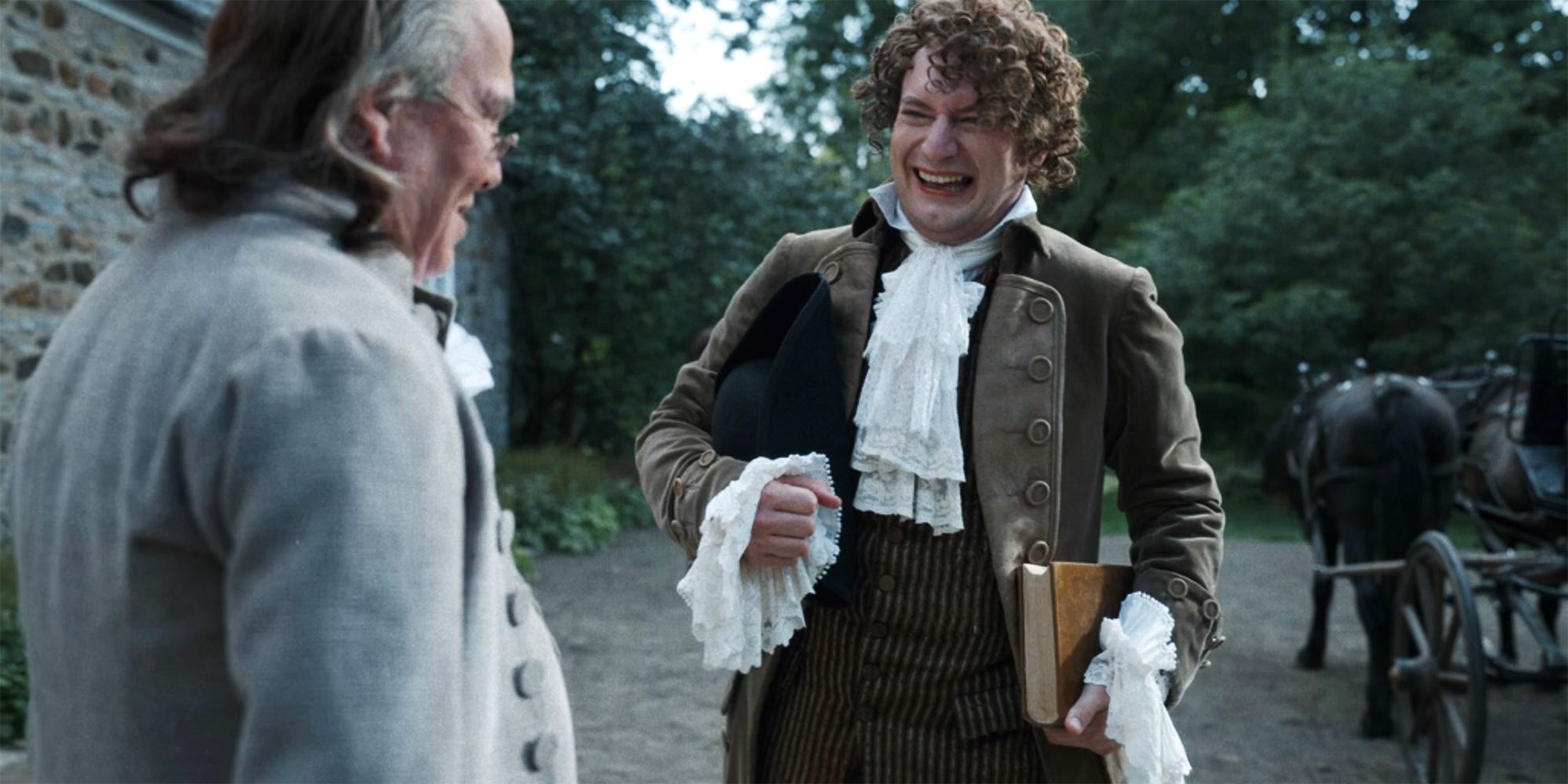 Isaac Higgintoot talking to Ben Franklin and smiling in Ghosts season 2