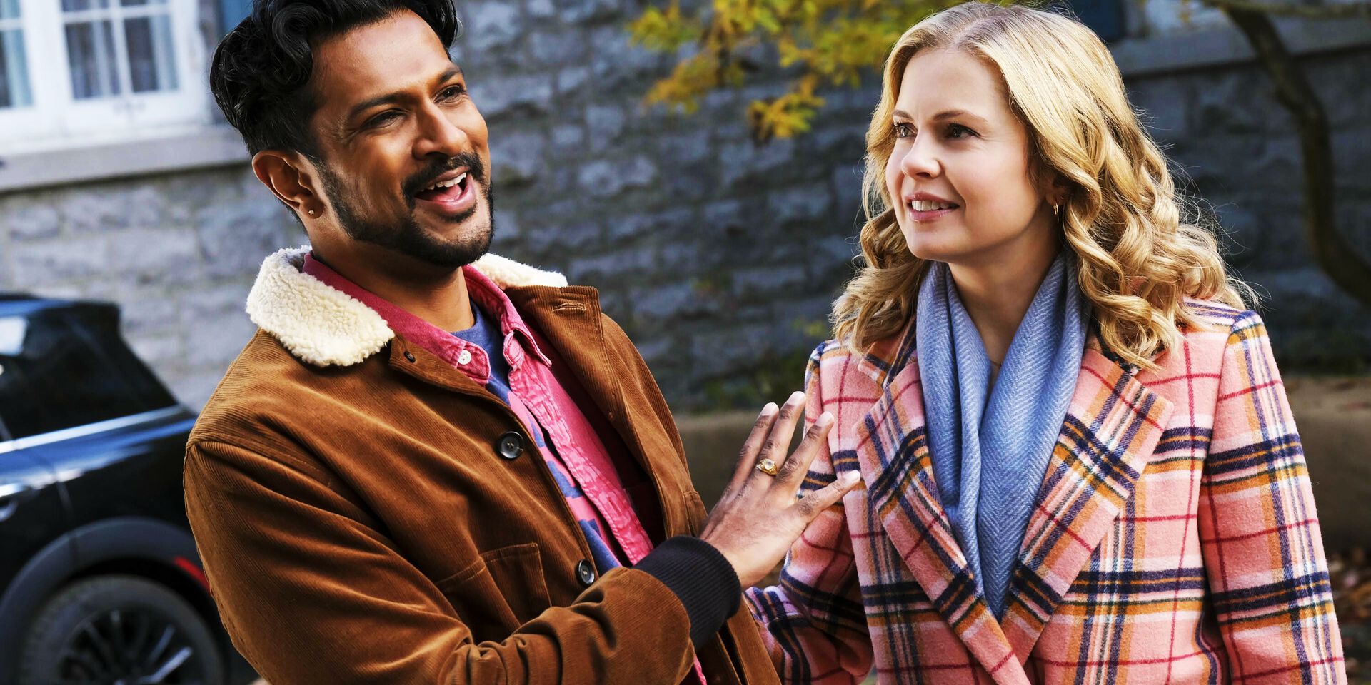 Jay laughs at Samantha in Ghosts as the couple stands outside in fall coats