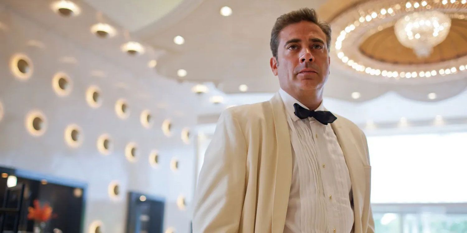 Jeffrey Dean Morgan as Ike Evans wearing a white suit in the lobby of his hotel in Magic City.