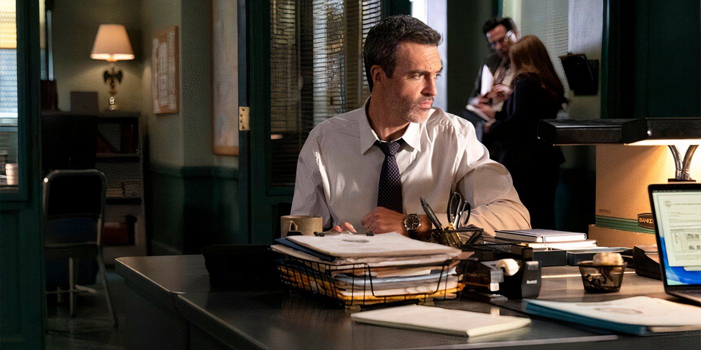 Reid olha pensativo enquanto trabalha em sua mesa em Law & Order