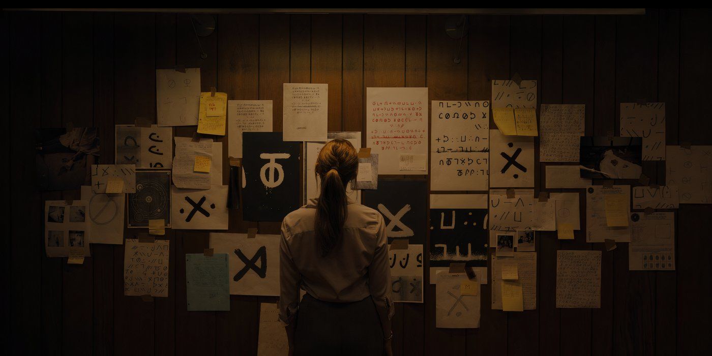 Maika Monroe stares at a wall of satanic symbols from evidence in Longlegs