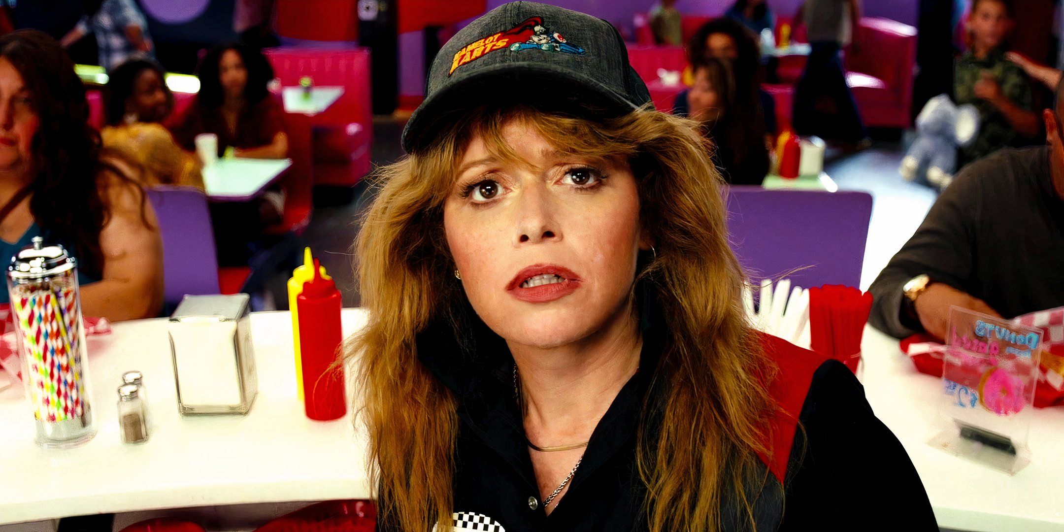 Natasha Lyonne como Charlie Cale olhando preocupada para uma tela de TV em Poker Face