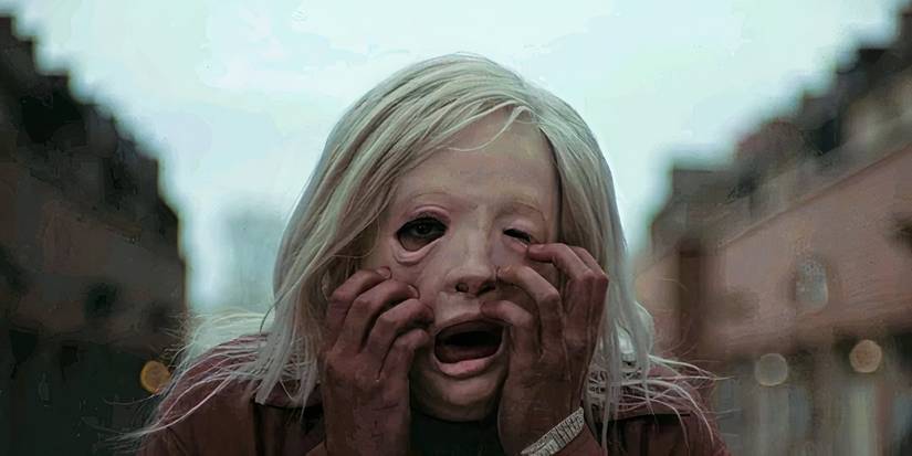 Colin (Christopher Abbott) grabs the face of his mask in Brandon Cronenberg's 2020 horror movie Possessor