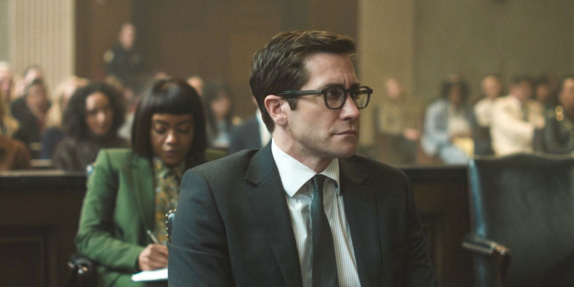 Rusty (Jake Gyllenhaal) in court with Mya taking notes behind him in Presumed Innocent Season 1 Episode 8