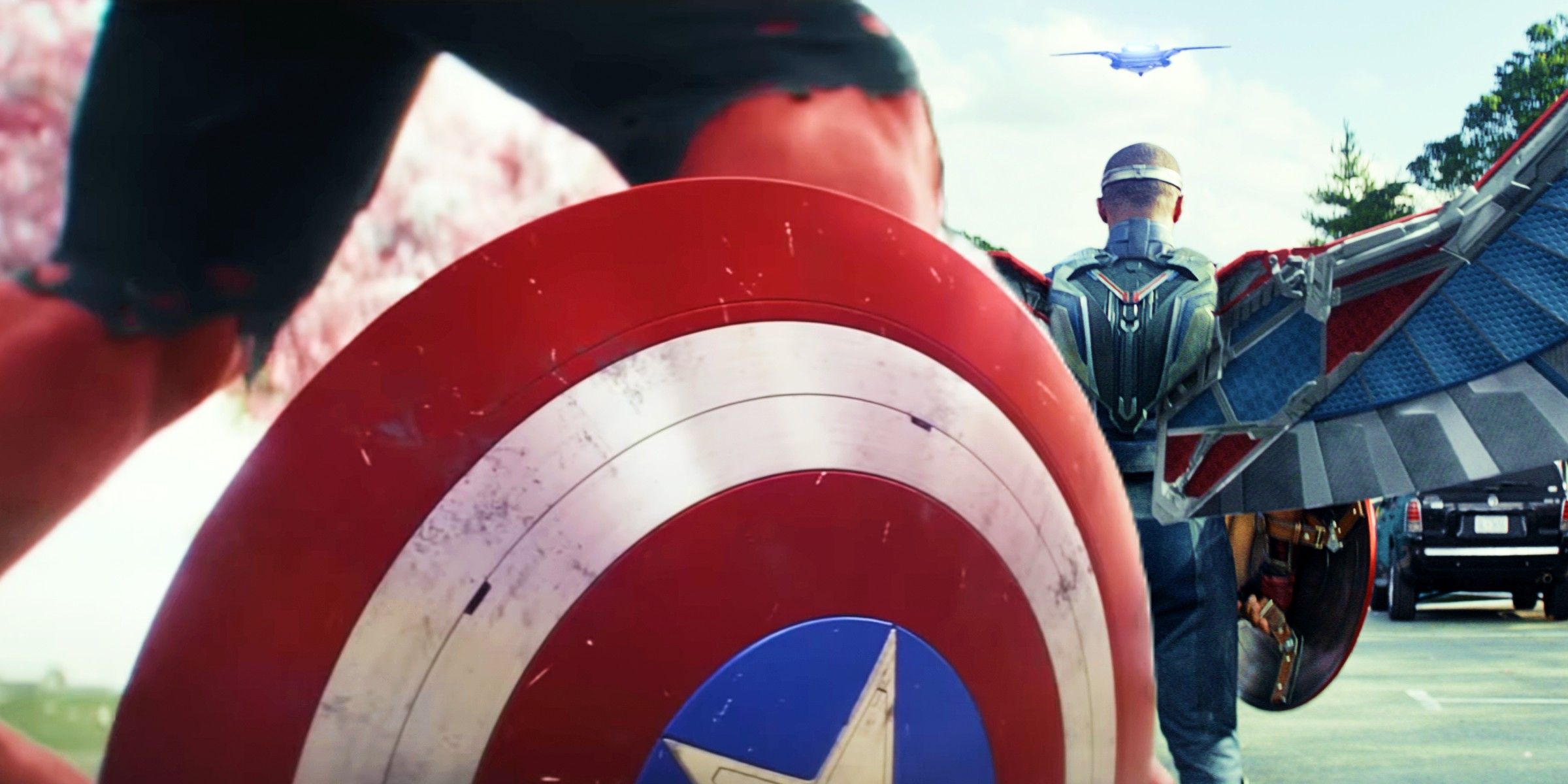 Red Hulk Legs Behind Captain America's Shield With Anthony Mackie As Sam Wilson Dressed In Captain America Costume With Back To The Camera in Captain America Brave New World