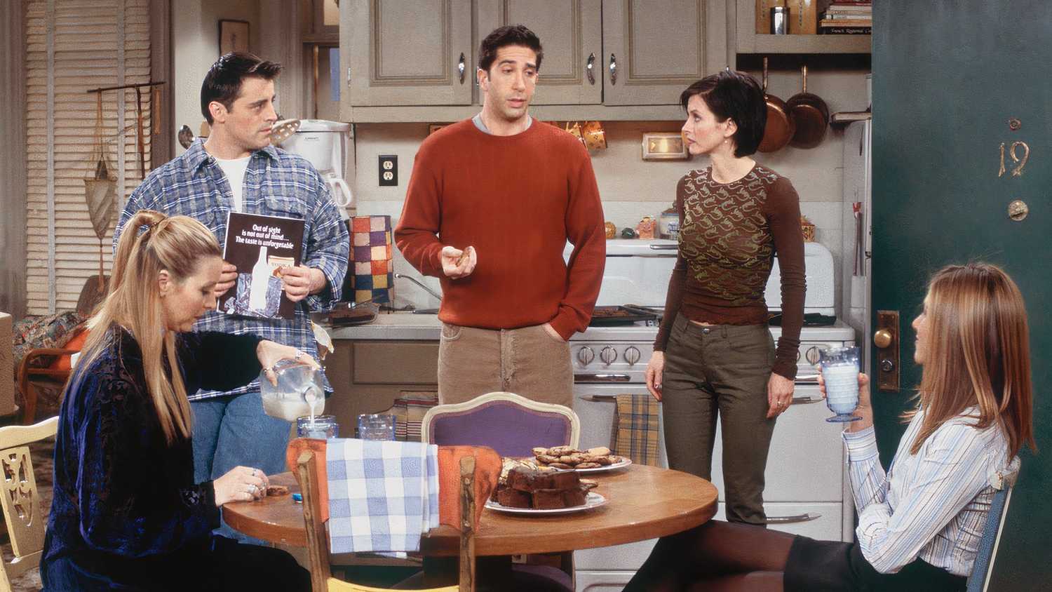 Ross talking in the apartment while Joey, Monica, and Rachel listen and Phoebe pours herself some milk in Friends
