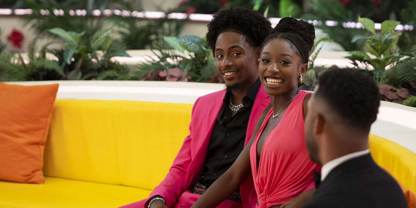 Love Island USA Temporada 6 Serena Paige y Cordell Beckham sonríen en el sofá con trajes rosas a juego.