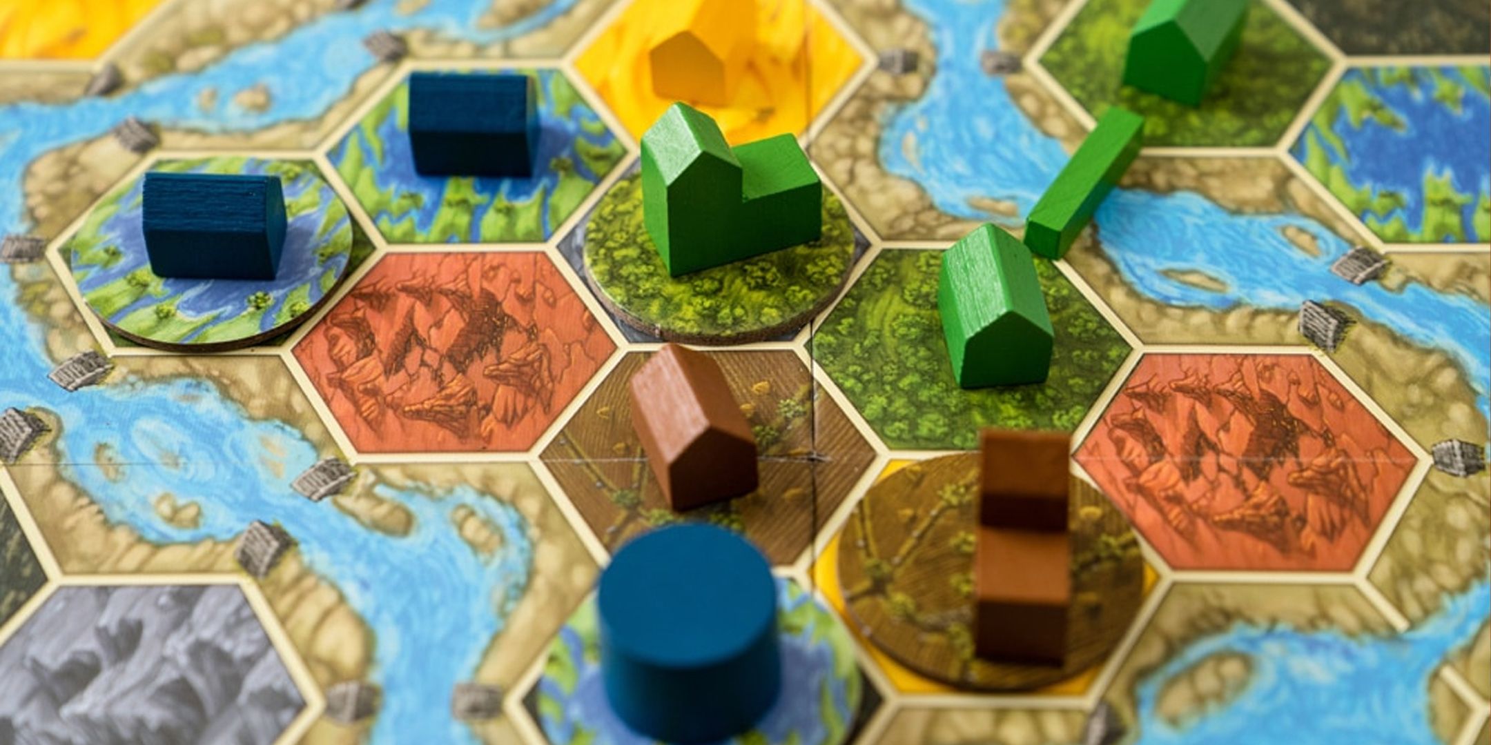 Um close do tabuleiro em Terra Mystica mostrando peças hexagonais com edifícios.