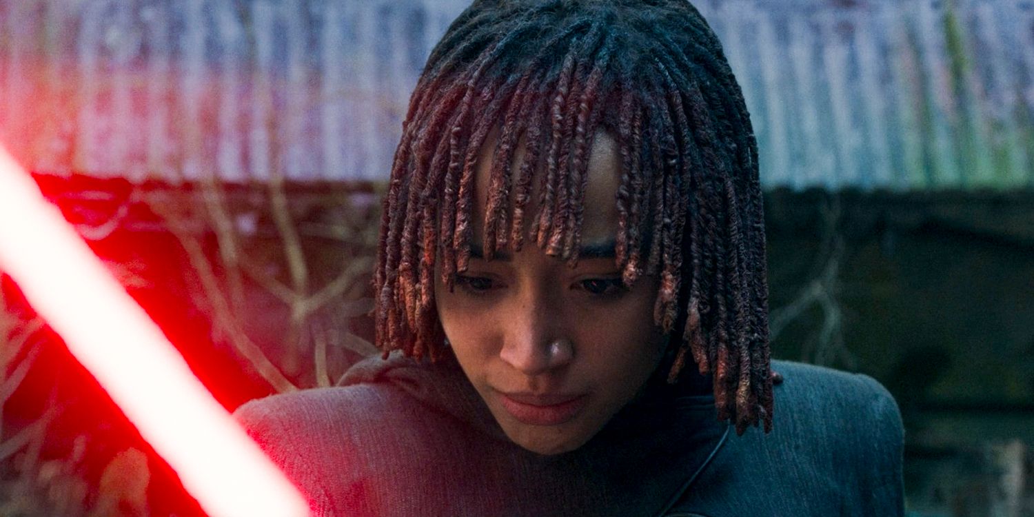 Osha (Amandla Stenberg) holding and staring intently at the lightsaber in The Acolyte season 1 episode 8